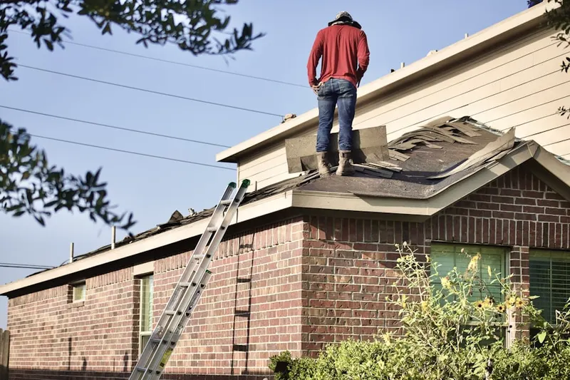 Professional roofer working on a residential roof in Buxton